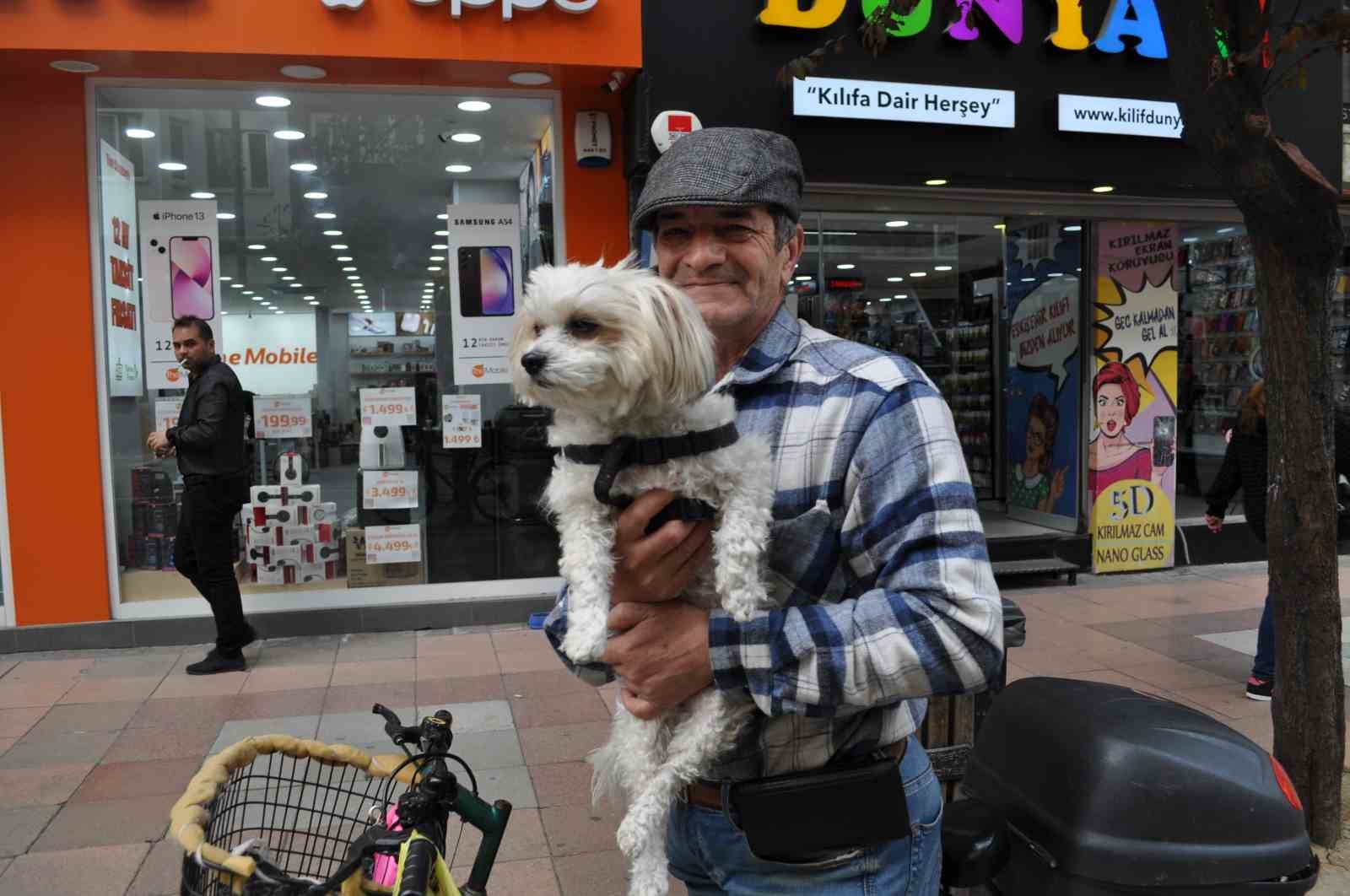 Köpeğini bisikletinin sepetine koyup güzel havanın tadını çıkardı
