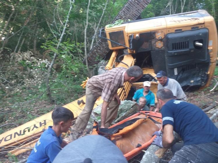 İş makinesi yol açma çalışmasında dik yamaçtan uçtu, operatör altında kaldı
