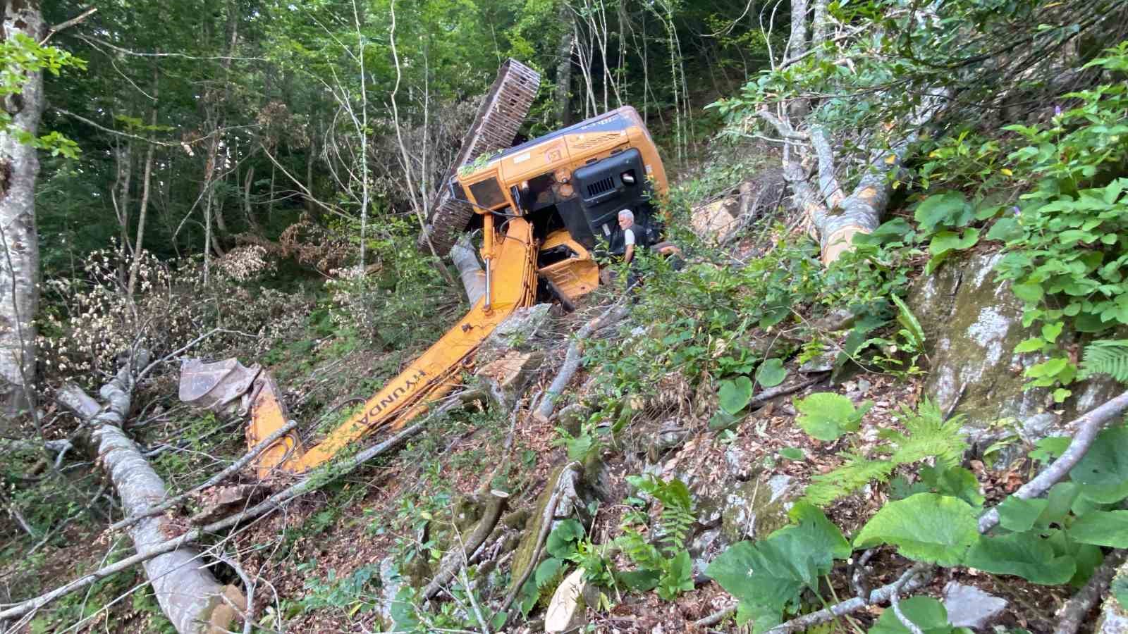 İş makinesi yol açma çalışmasında dik yamaçtan uçtu, operatör altında kaldı
