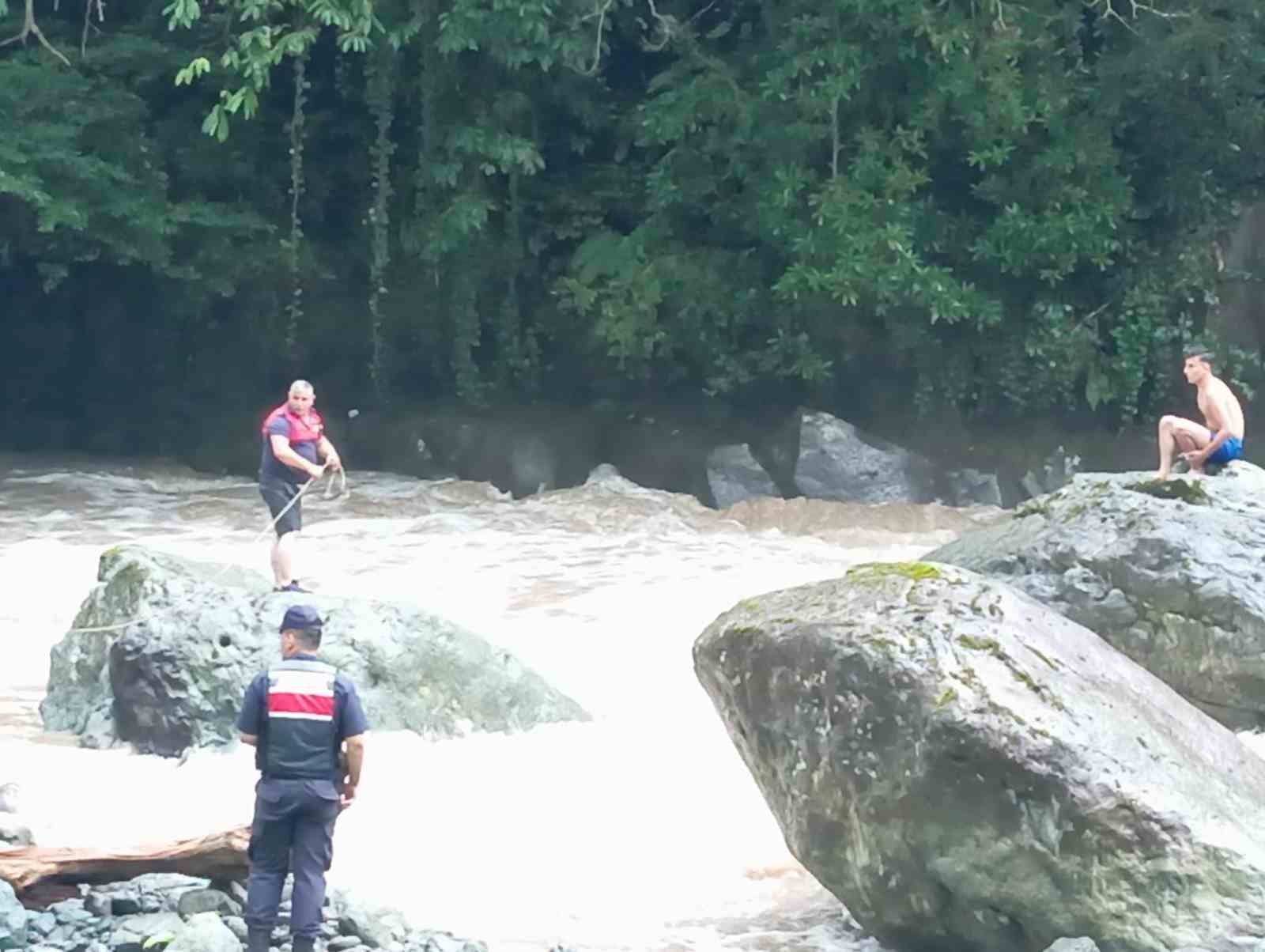 Serinlemek için girdikleri derede su seviyesi yükselince kayalar üzerinde mahsur kaldılar
