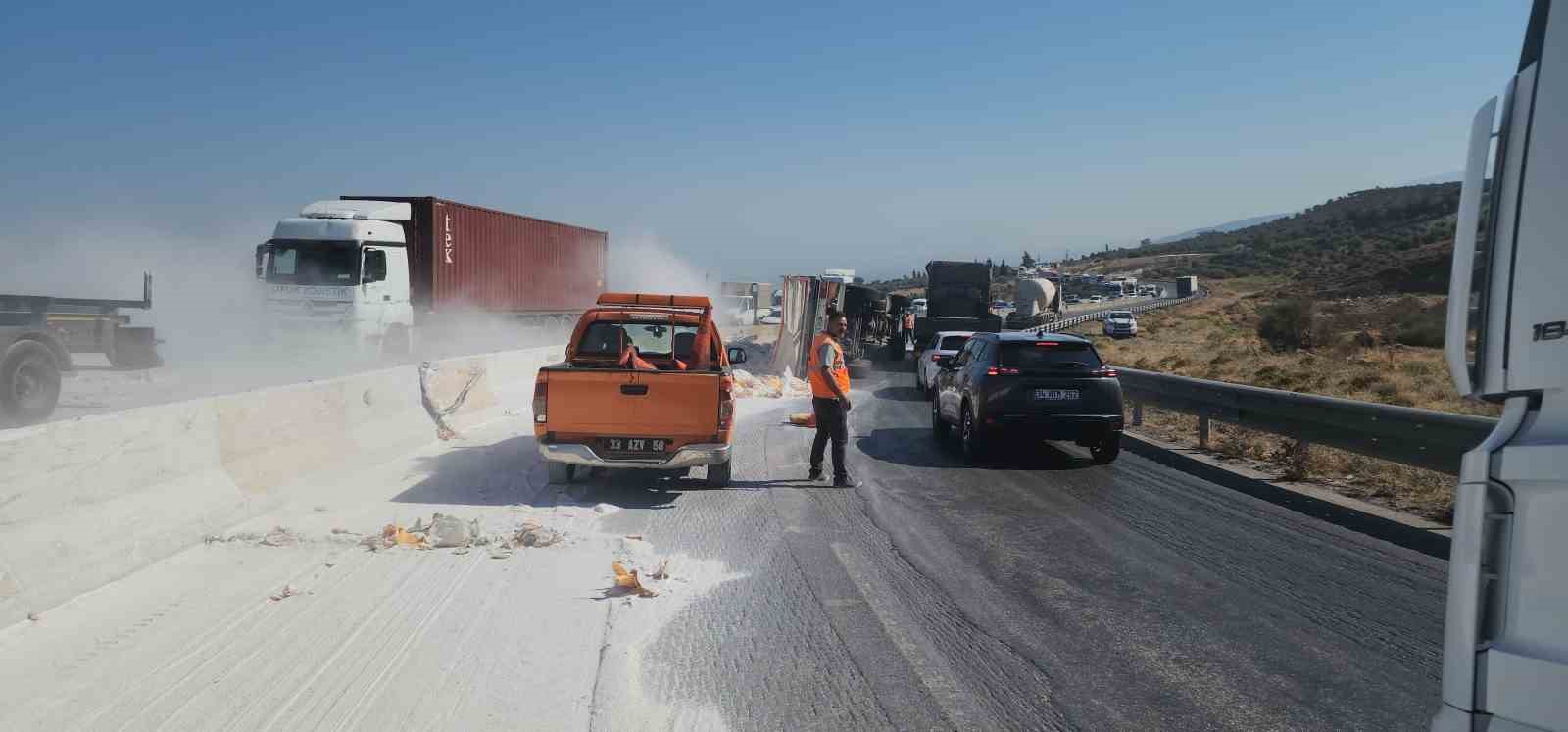 Devrilen tırdan onlarca çimento torbası yola savruldu
