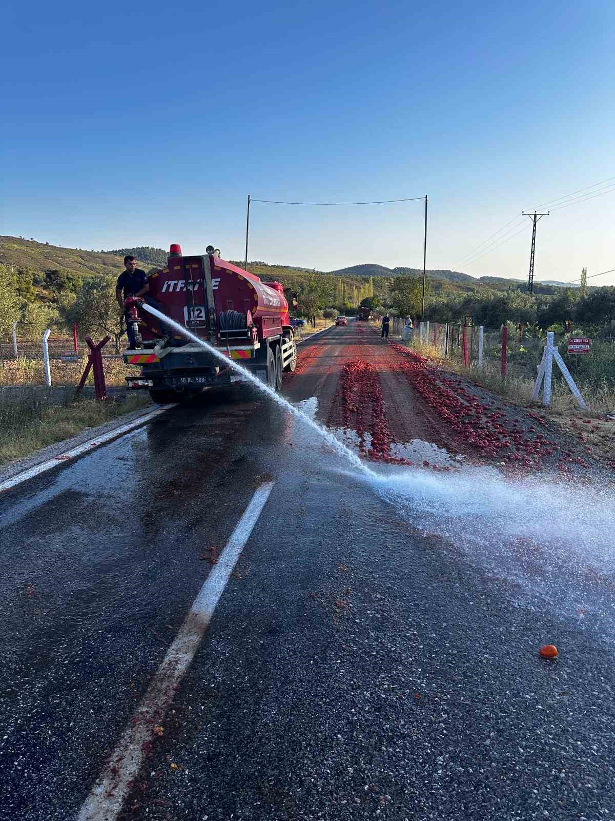 İzmir’deki yangını söndüren itfaiye erleri, Manisa’da yola saçılan domatesleri temizledi
