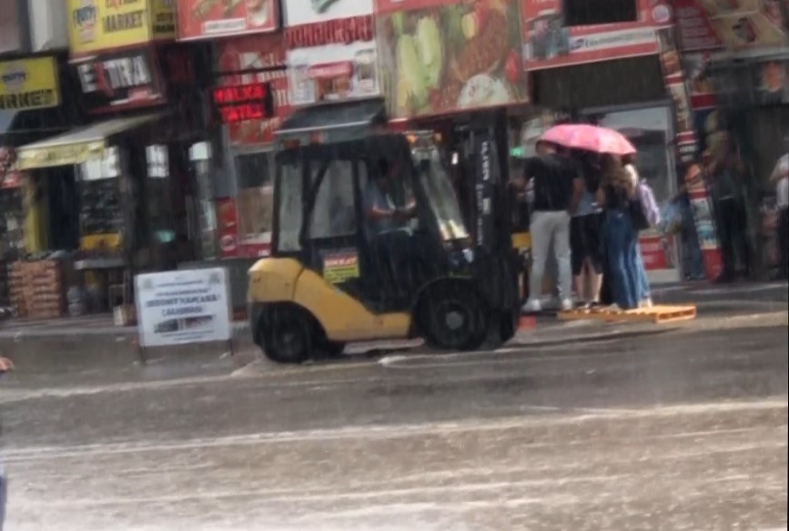 Aniden başlayan yağış sonrası yayaların imdadına belediye forkliftle yetişti
