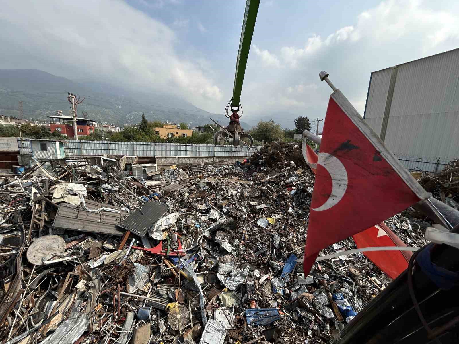 Hurda yığını içerisindeki Türk bayrağını elleriyle çıkararak iş makinesine astı
