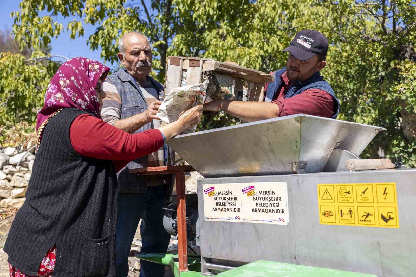 Üzüm sıkma makinesi çalışıyor, üretici keyfine bakıyor
