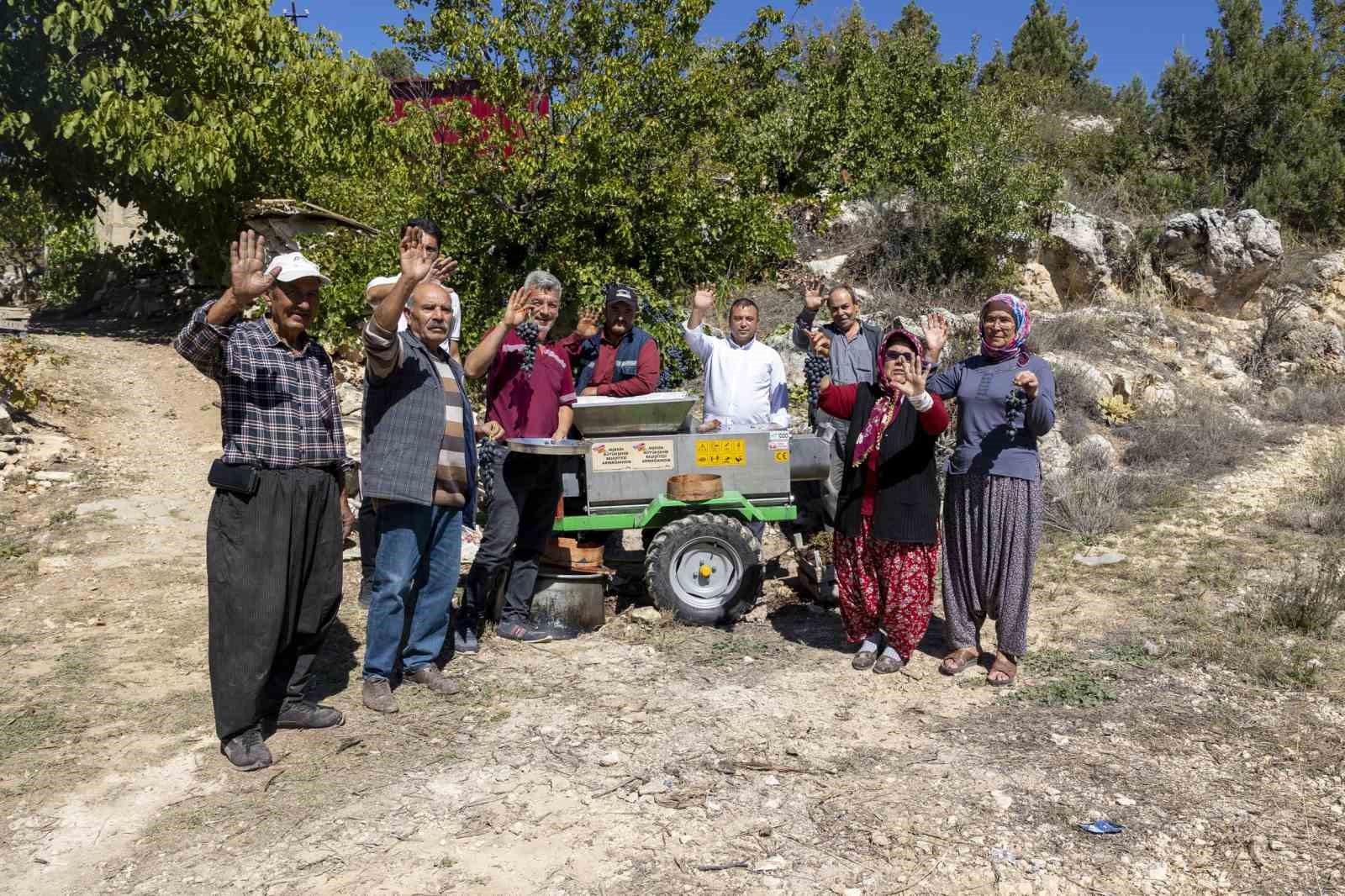 Üzüm sıkma makinesi çalışıyor, üretici keyfine bakıyor
