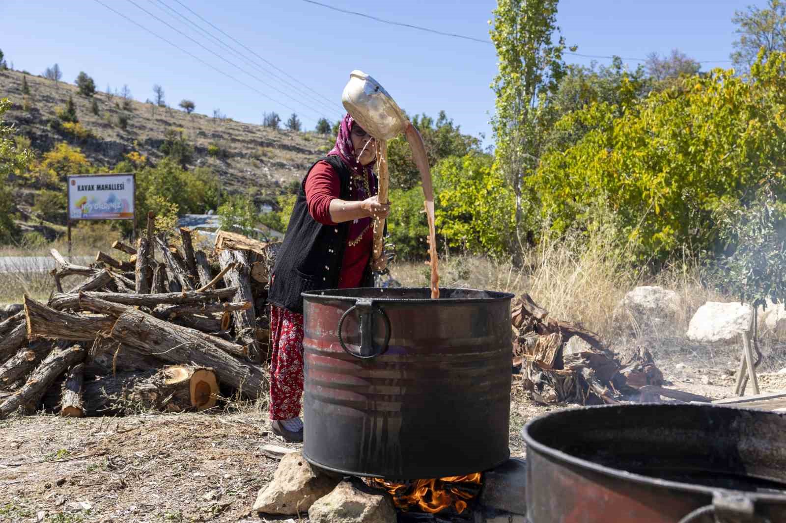 Üzüm sıkma makinesi çalışıyor, üretici keyfine bakıyor
