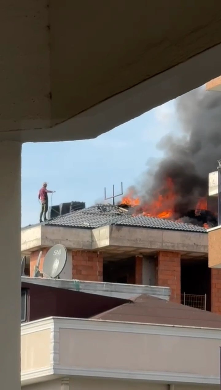 Pendik’te inşaat halindeki bir binanın çatısındaki yangını bir vatandaş hortumla söndürmeye çalıştı
