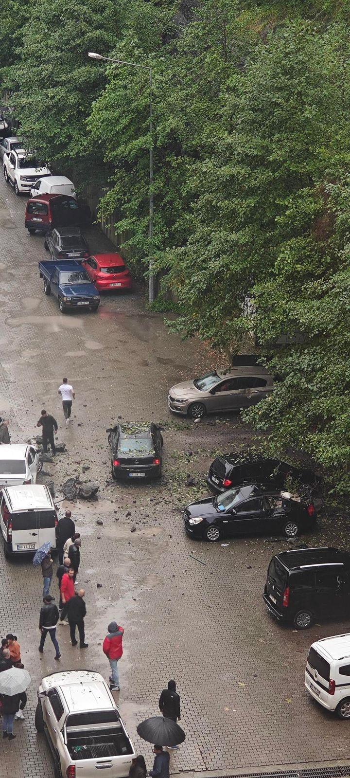 Artvin’in Hopa ilçesinde yamaçtan kopan kayalar park halindeki 7 araca hasar verdi
