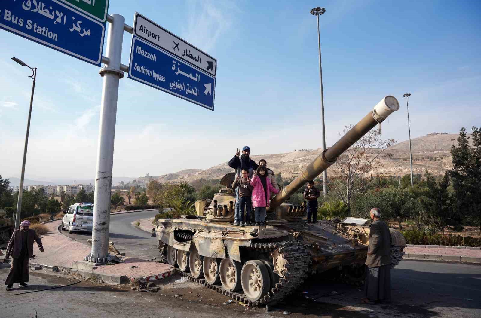 Suriyelilerden Esad rejiminden geriye kalan tankların üzerinde “zafer” pozu
