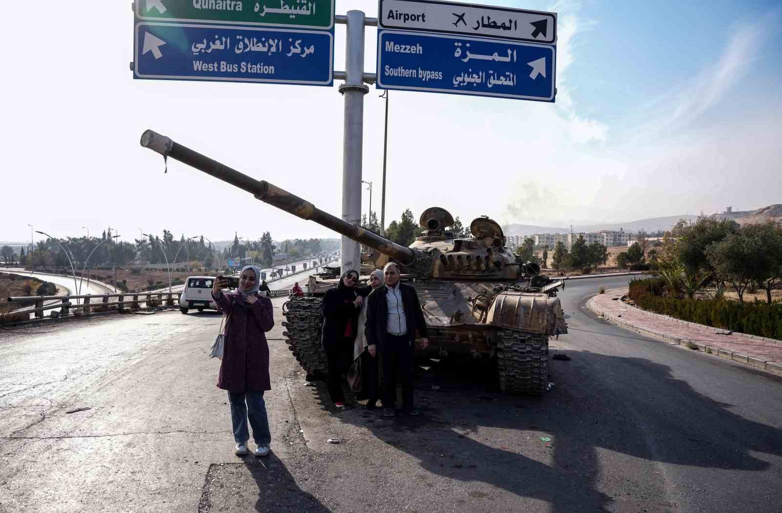 Suriyelilerden Esad rejiminden geriye kalan tankların üzerinde “zafer” pozu
