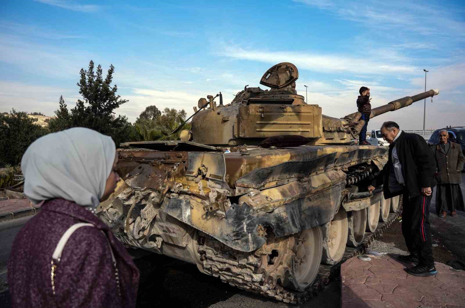 Suriyelilerden Esad rejiminden geriye kalan tankların üzerinde “zafer” pozu
