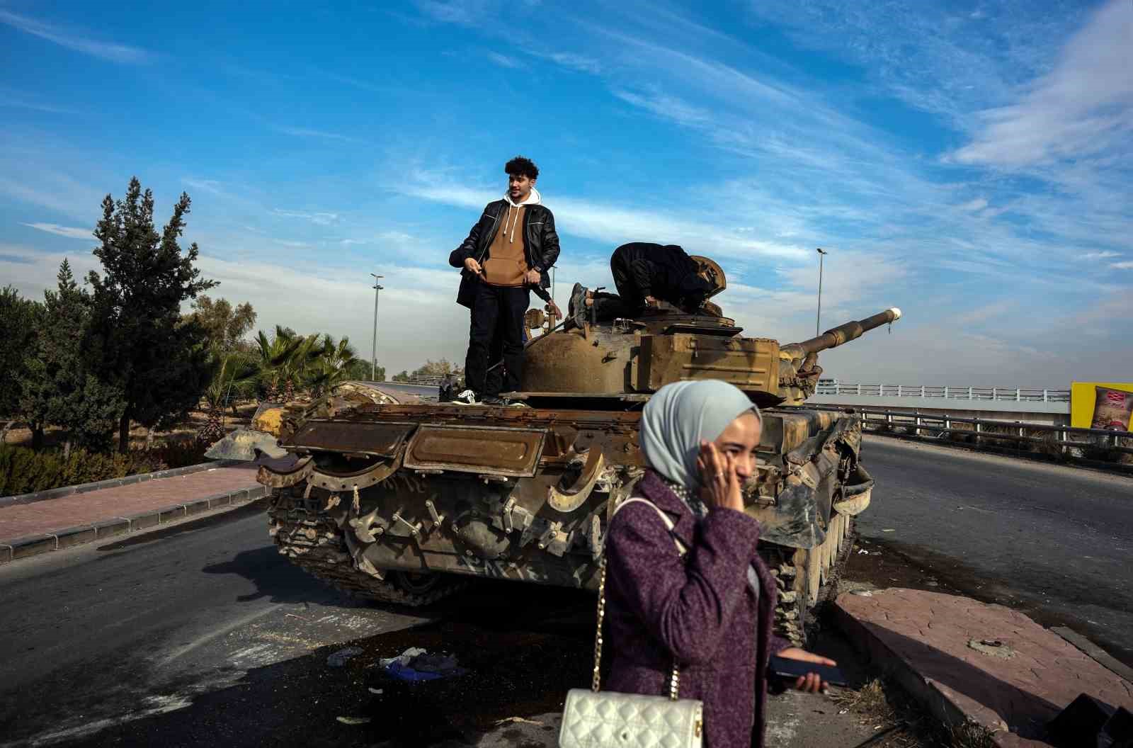 Suriyelilerden Esad rejiminden geriye kalan tankların üzerinde “zafer” pozu
